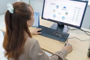 Young woman using desktop computer in office setting in Hanoi, Vietnam.